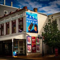 Exterior of the Parnell Store Smashed It with a large blue billboard promoting fast phone and Mac repair services.